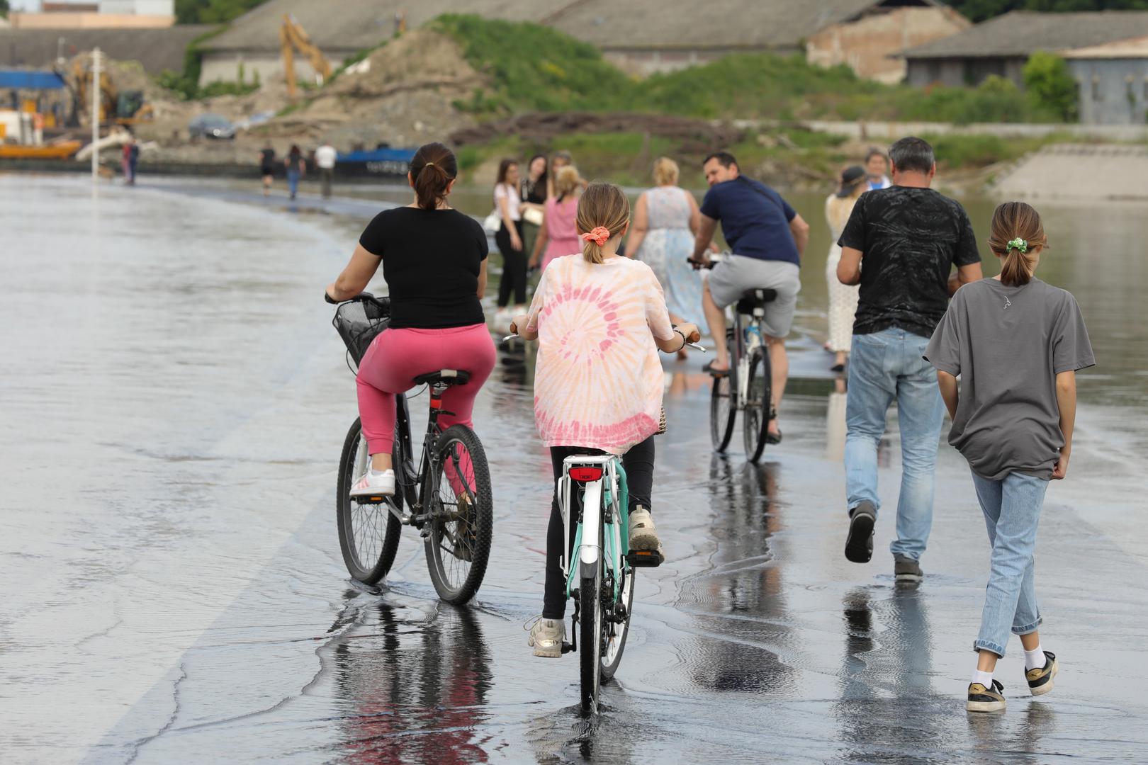 22.05.2023., Osijek - Vodostaj rijeke Drave raste iz sata u sat i dosegao je +356 centimetara. Prilaz novog luckog terminala preplavila je voda sto je Osjecanima bila prilika prosetati ''po vodi'' i napraviti zanimljive fotografije. Photo: Dubravka Petric/PIXSELL