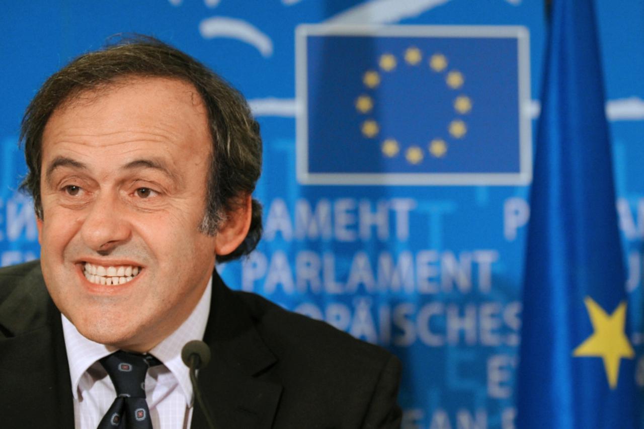 'UEFA President Michel Platini (R) speaks during his meeting with European Parliament President Jerzy Buzek (out of camera range) as they sign the ball  on November 5, 2009 in Brussels. AFP PHOTO/JOHN