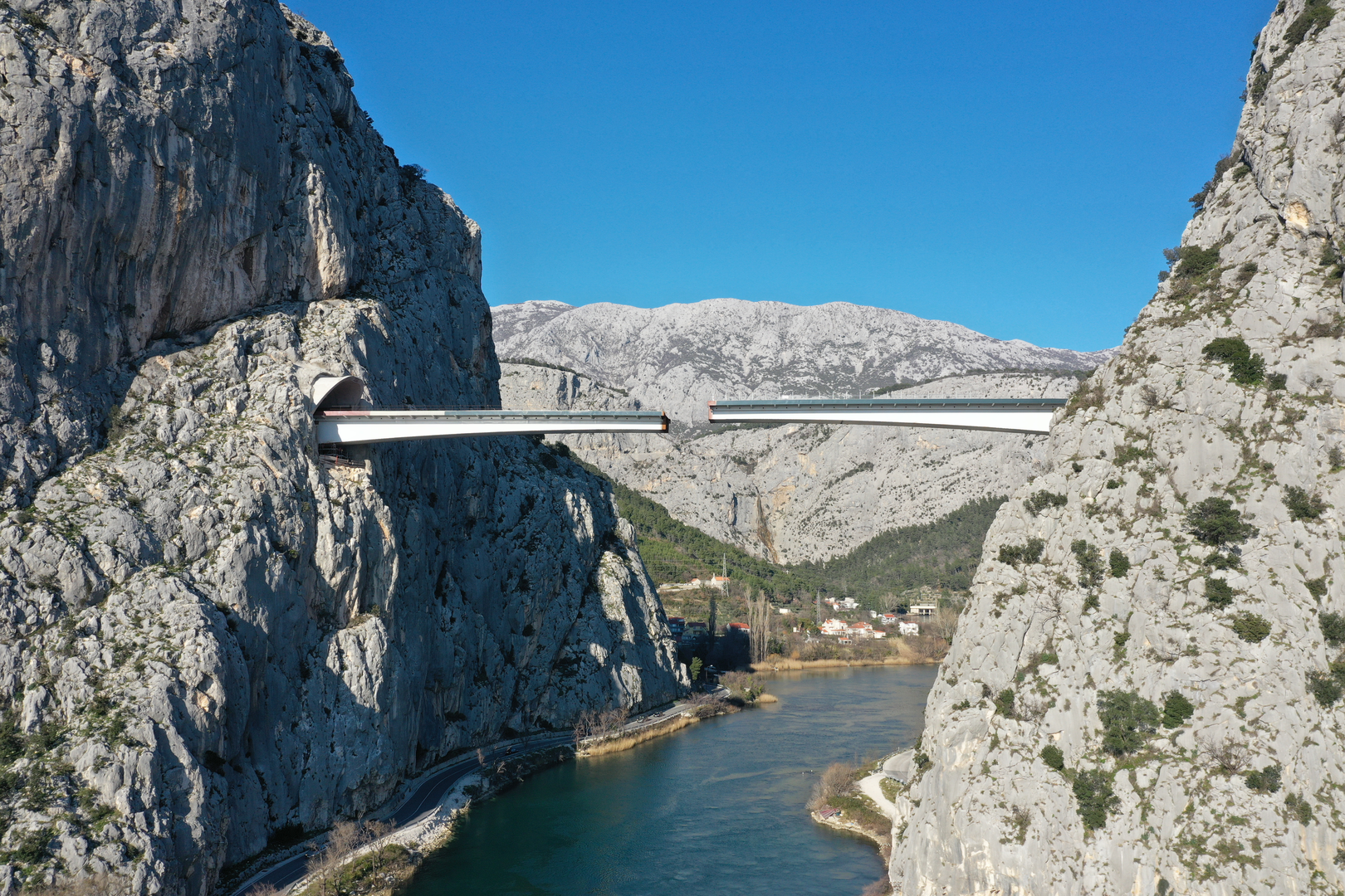 09.02.2023., Omis - Spajanje mosta iznad rijeke Cetine kod Omisa na 70 metara nadmorske visine koji je dio omiske zaobilaznice. Omiska obilaznica jedan od najvecih infrastrukturnih objekata u Splitsko-dalmatinskoj zupaniji, a zaobilaznicu ukljucuju dva tunela i most preko Cetine, tunel Komorjak dug vise od 600 metara, a Omis vise od 500 metara, dok ce most biti u duzini od 216 metara. Investitor je tvrtka Hrvatske ceste, koja je za prvu fazu brze ceste Split - Omis izdvojila 174,5 milijuna kuna, a s radovima se pocelo u rujnu 2019.  Photo: Matko Begovic/PIXSELL