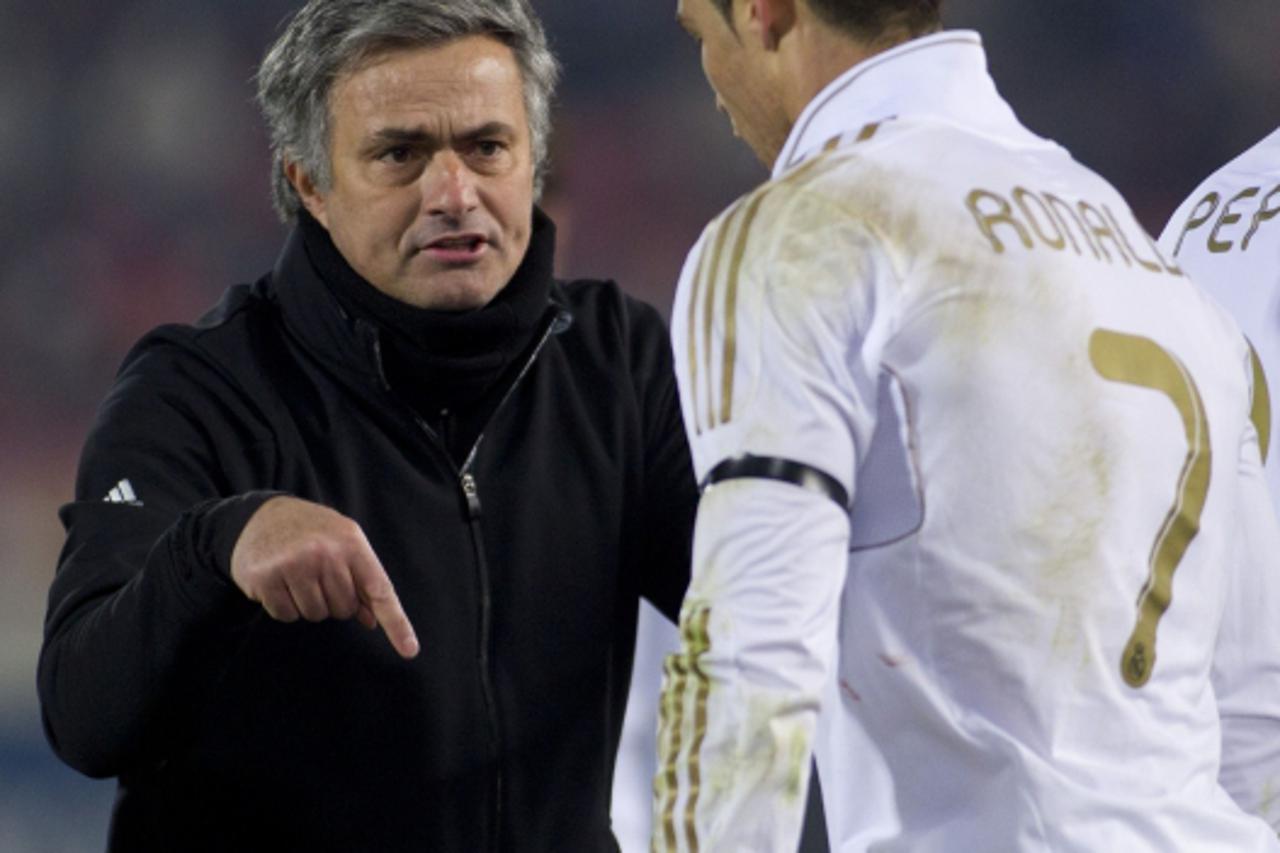 'Real Madrid\'s Portuguese coach Jose Mourinho (L) speaks with Real Madrid\'s Portuguese forward Cristiano Ronaldo during the Spanish league football match Mallorca vs Real Madrid on January 14, 2012 