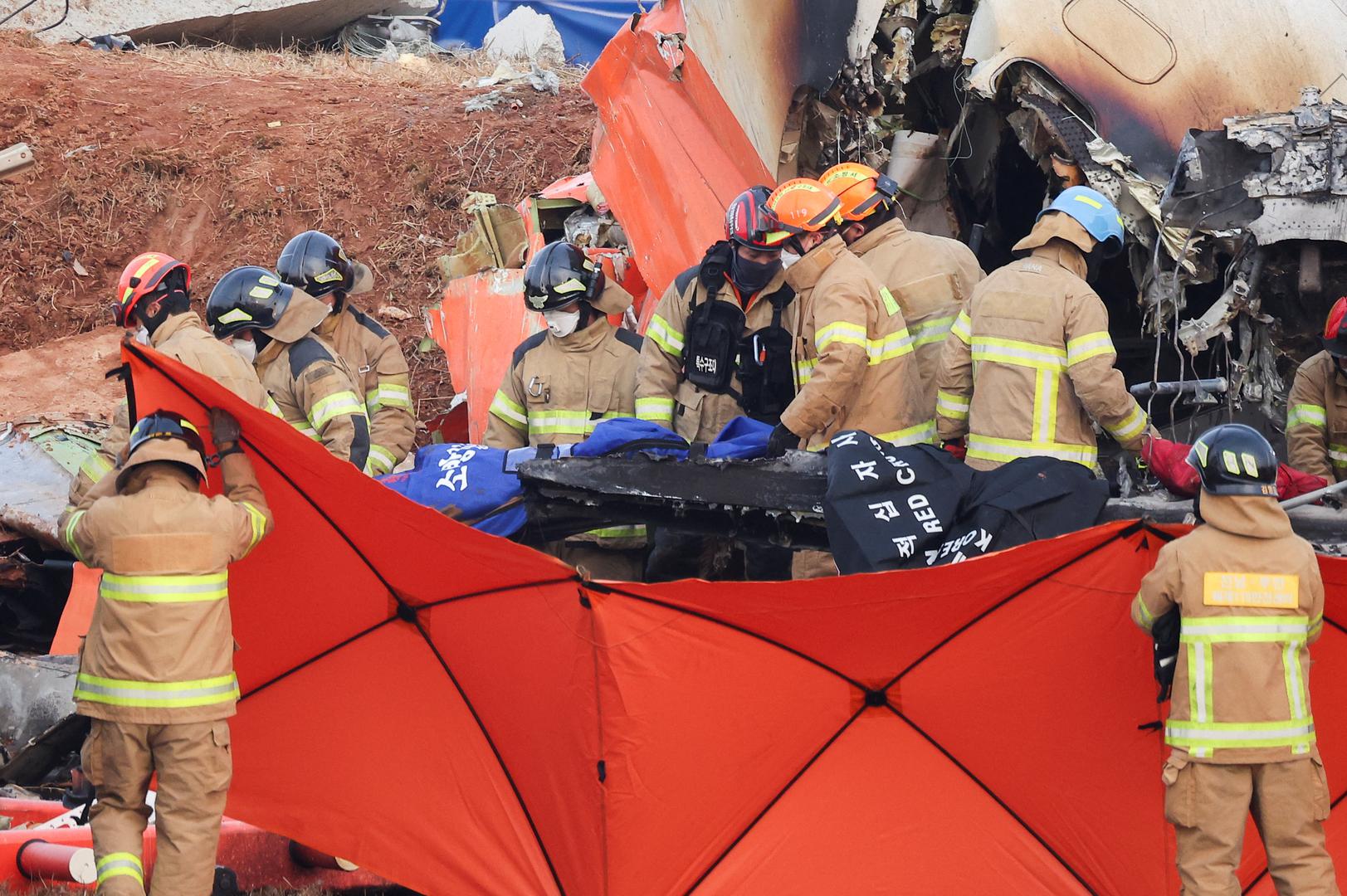 Firefighters carry the body of a passenger from the wreckage of an aircraft that crashed after it went off the runway at Muan International Airport, in Muan, South Korea, December 29, 2024. REUTERS/Kim Hong-Ji Photo: KIM HONG-JI/REUTERS