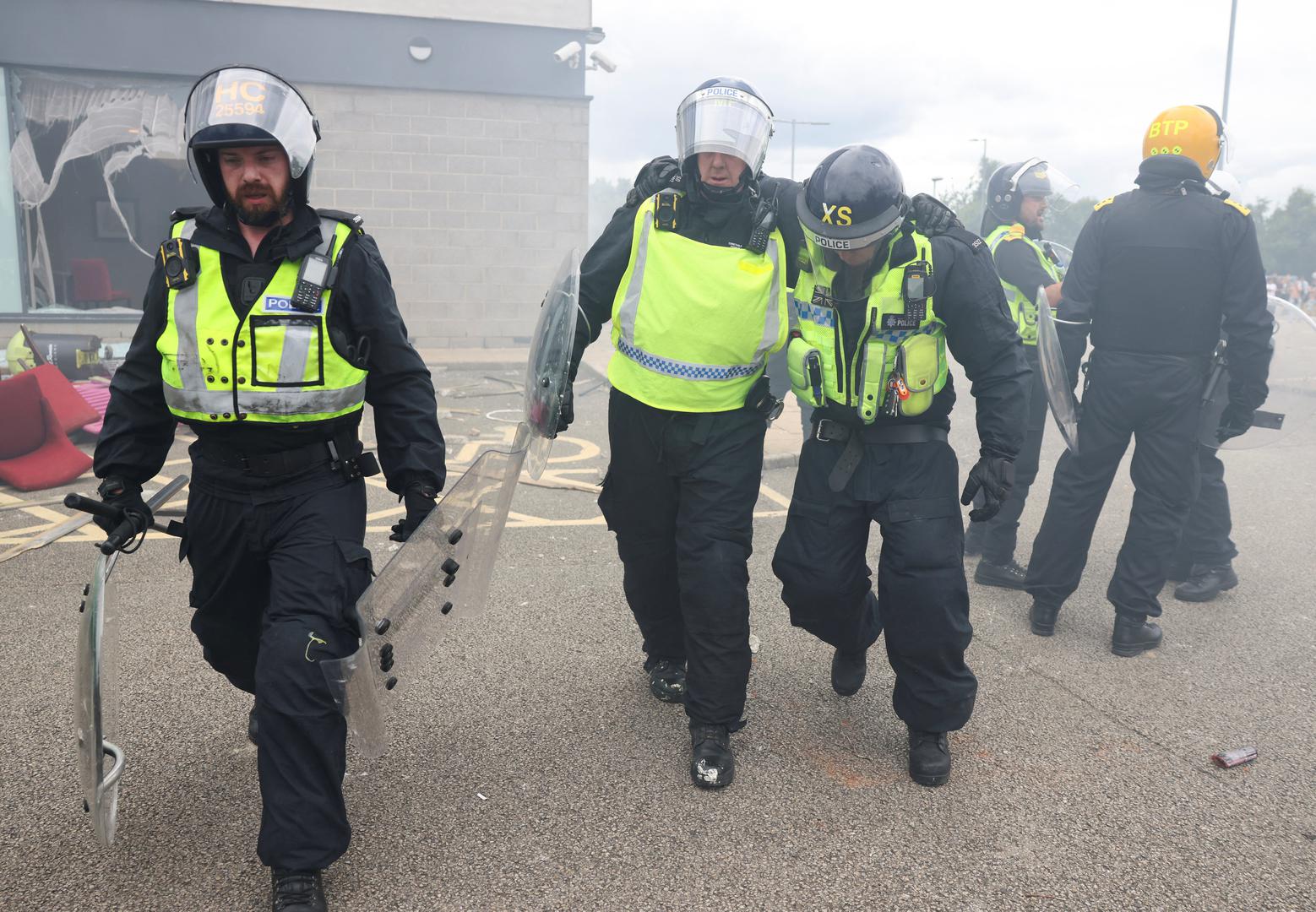 A police officer, who is believed to be injured during a clash with protestors leaves the site as he is assisted outside a hotel in Rotherham, Britain, August 4, 2024. REUTERS/Hollie Adams Photo: Hollie Adams/REUTERS