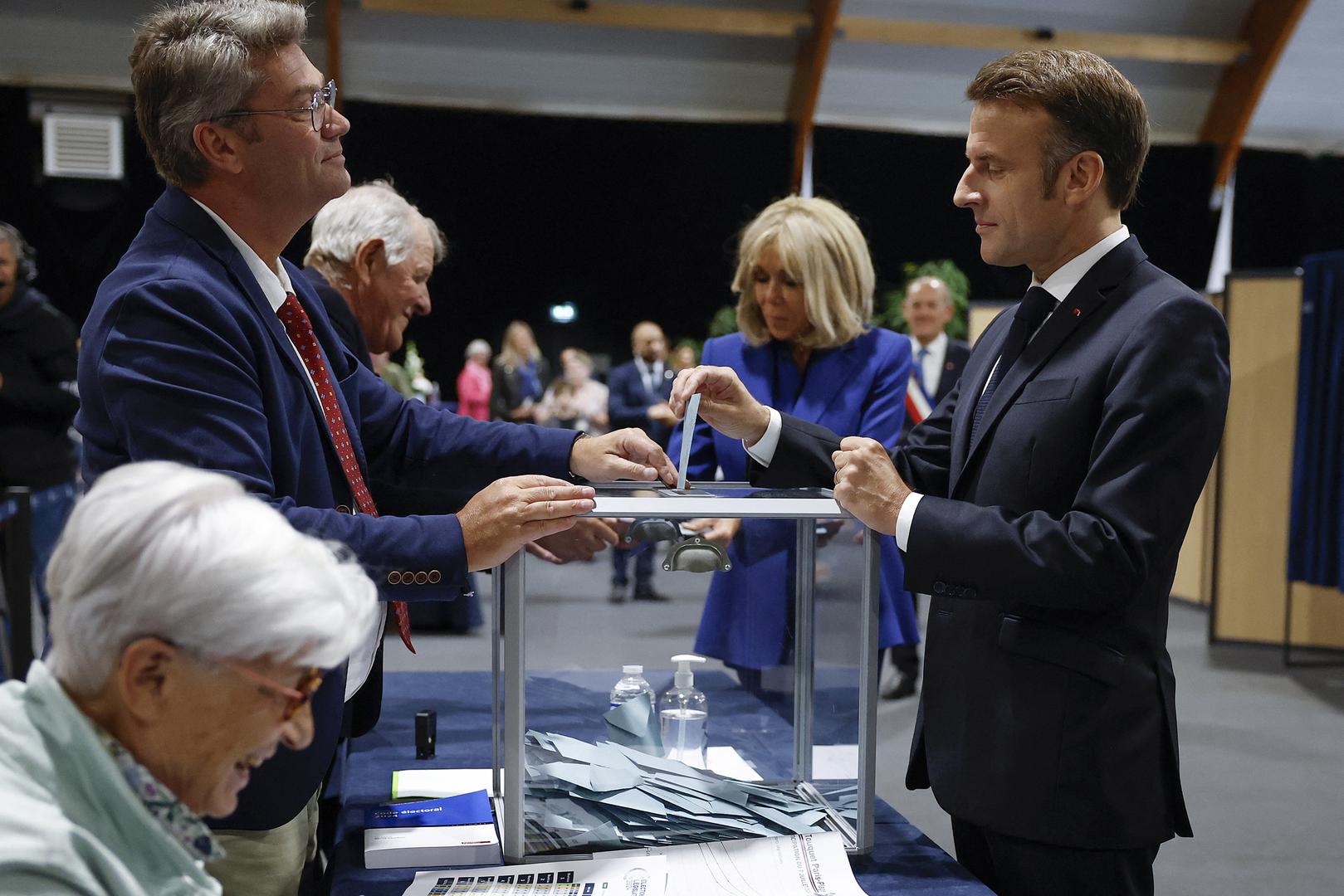 French President Emmanuel Macron (R) casts his ballot flanked by French First Lady Brigitte Macron (C) at a polling station to vote in the second round of French parliamentary elections in Le Touquet-Paris-Plage, France, 07 July 2024.  MOHAMMED BADRA/Pool via REUTERS Photo: MOHAMMED BADRA / POOL/REUTERS