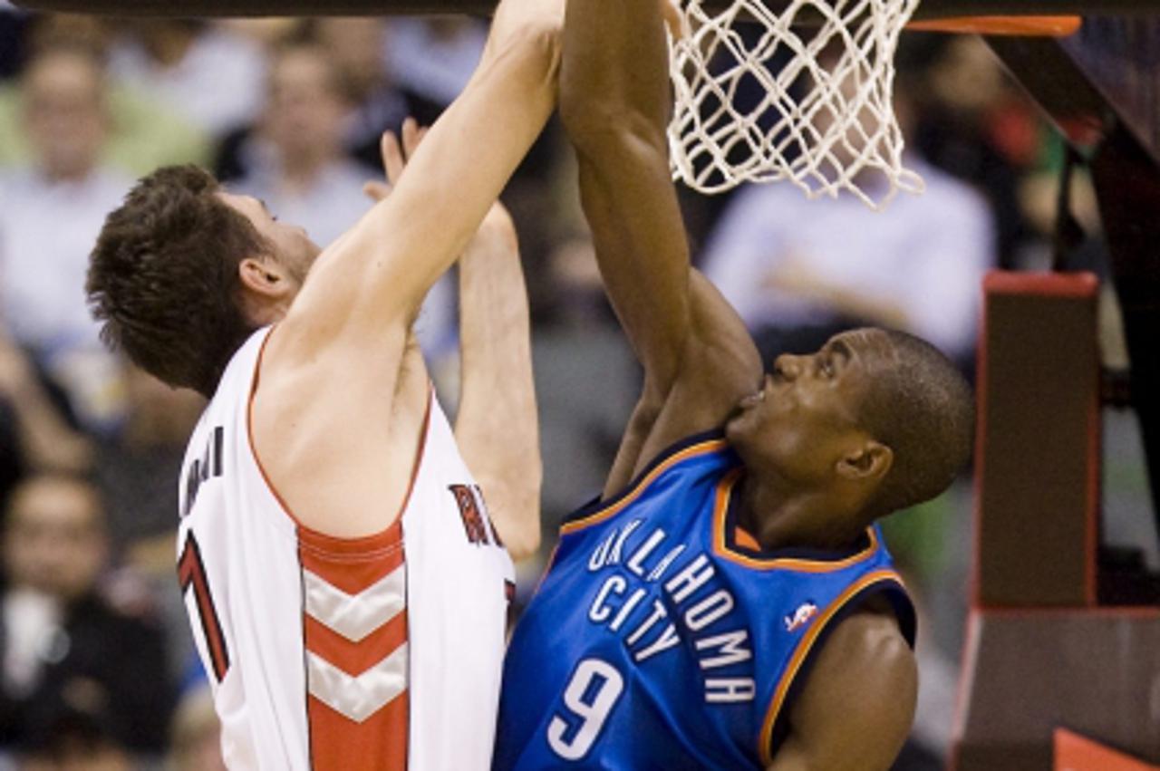 'Toronto Raptors\' Andrea Bargnani, left, has his attempted dunk rejected by Oklahoma City Thunder\'s Serge Ibaka during first half NBA basketball action against the Toronto Raptors in Toronto Friday,