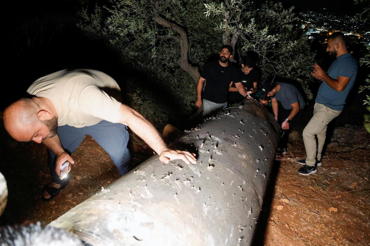 Palestinians investigate a projectile, after Iran fired a salvo of ballistic missiles, in Tubas