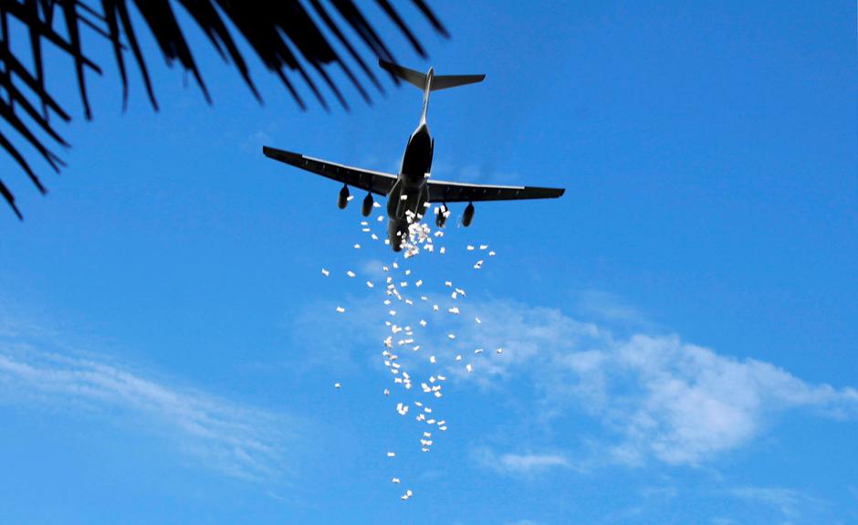 FILE PHOTO: A United Nations World Food Programme plane releases sacks of food during an airdrop near the town of Nyal