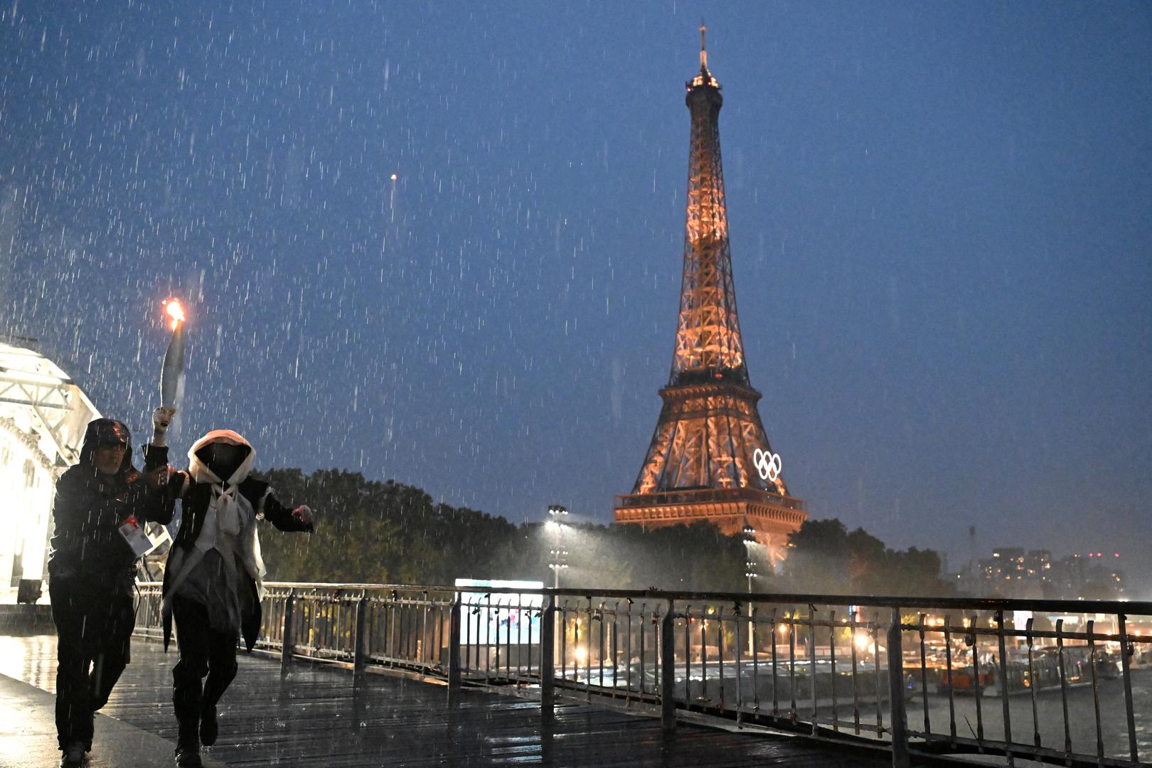 Paris 2024 Olympics - Opening Ceremony - Paris, France - July 26, 2024.  A torchbearer runs during the opening ceremony of the Paris 2024 Olympic Games in Paris, France, July 26, 2024.     Li An/Pool via REUTERS Photo: Li An/REUTERS