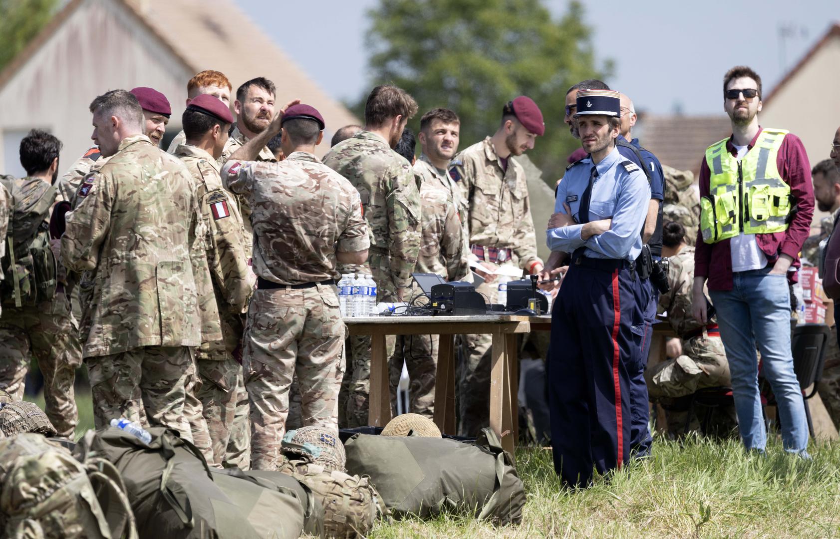 Paratroopers queue to show their passports to French customs control after landing in a field after making a commemorative jump into fields around the French village of Sanneville in Normandy as part of the 80th anniversary of D-day. 05.06.2024   Material must be credited "The Times/News Licensing" unless otherwise agreed. 100% surcharge if not credited. Online rights need to be cleared separately. Strictly one time use only subject to agreement with News Licensing Photo: Richard Pohle/NEWS SYNDICATION