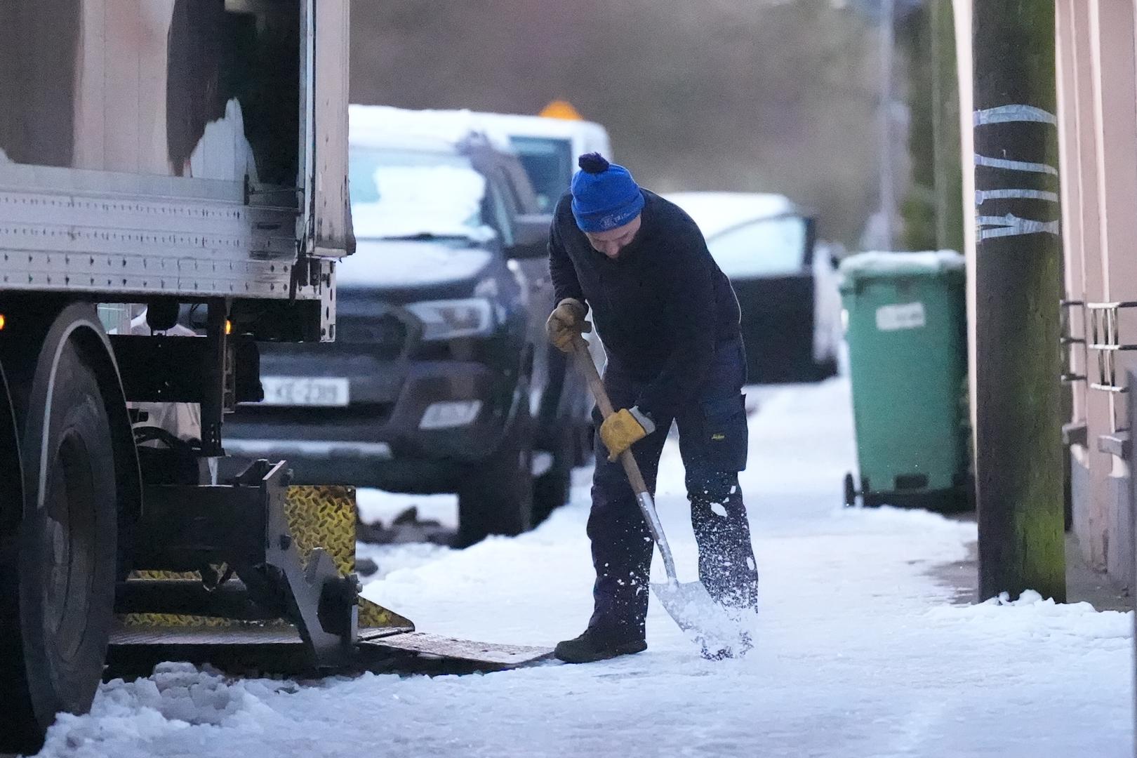 A man clears snow from the pathway in the village of Ballylynan in County Laois in Ireland. Tens of thousands of homes and businesses in Ireland are without water and electricity amid a bitter cold snap across the whole island. Picture date: Monday January 6, 2025. Photo: Niall Carson/PRESS ASSOCIATION